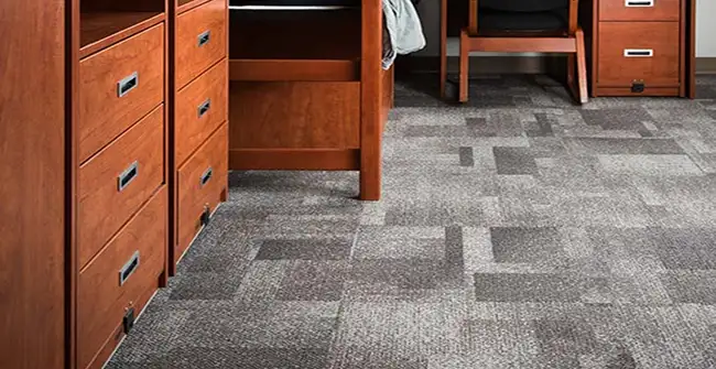 dorm room with gray carpet tiles installed