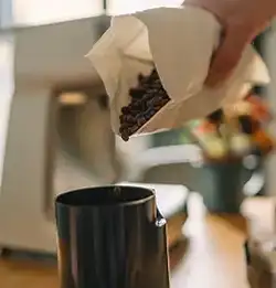 Coffee beans being poured out of flexible packaging