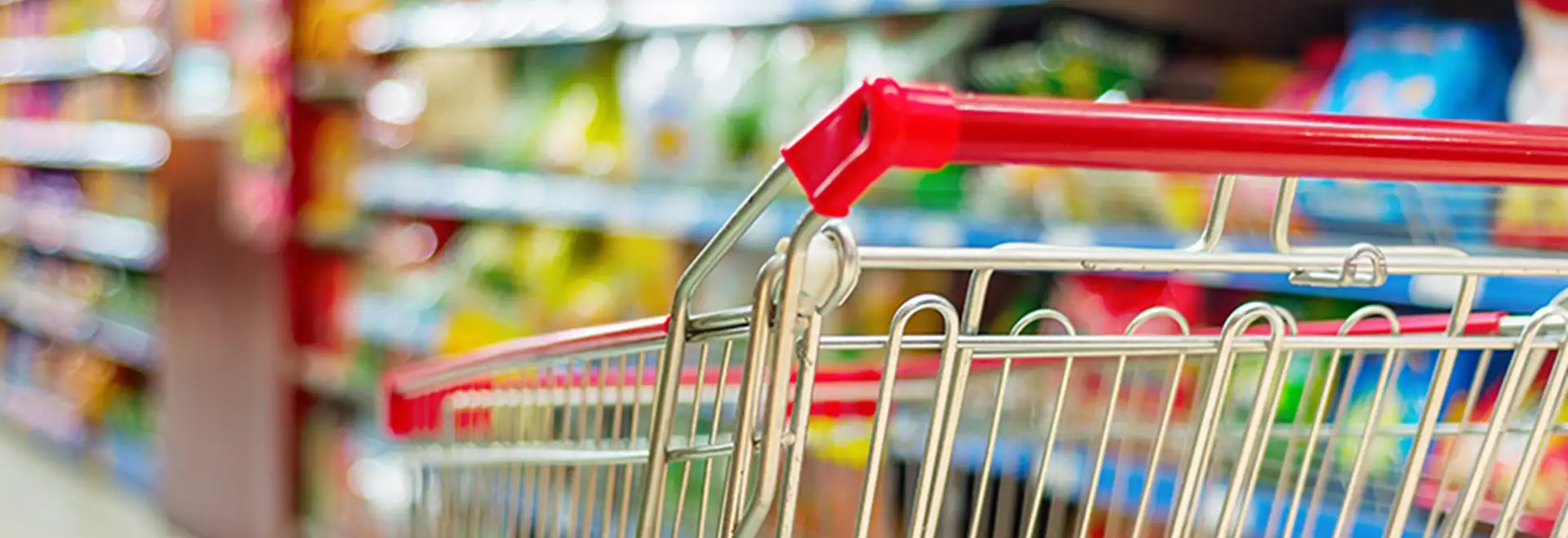 close up of shoping cart with blurred store shelves in background