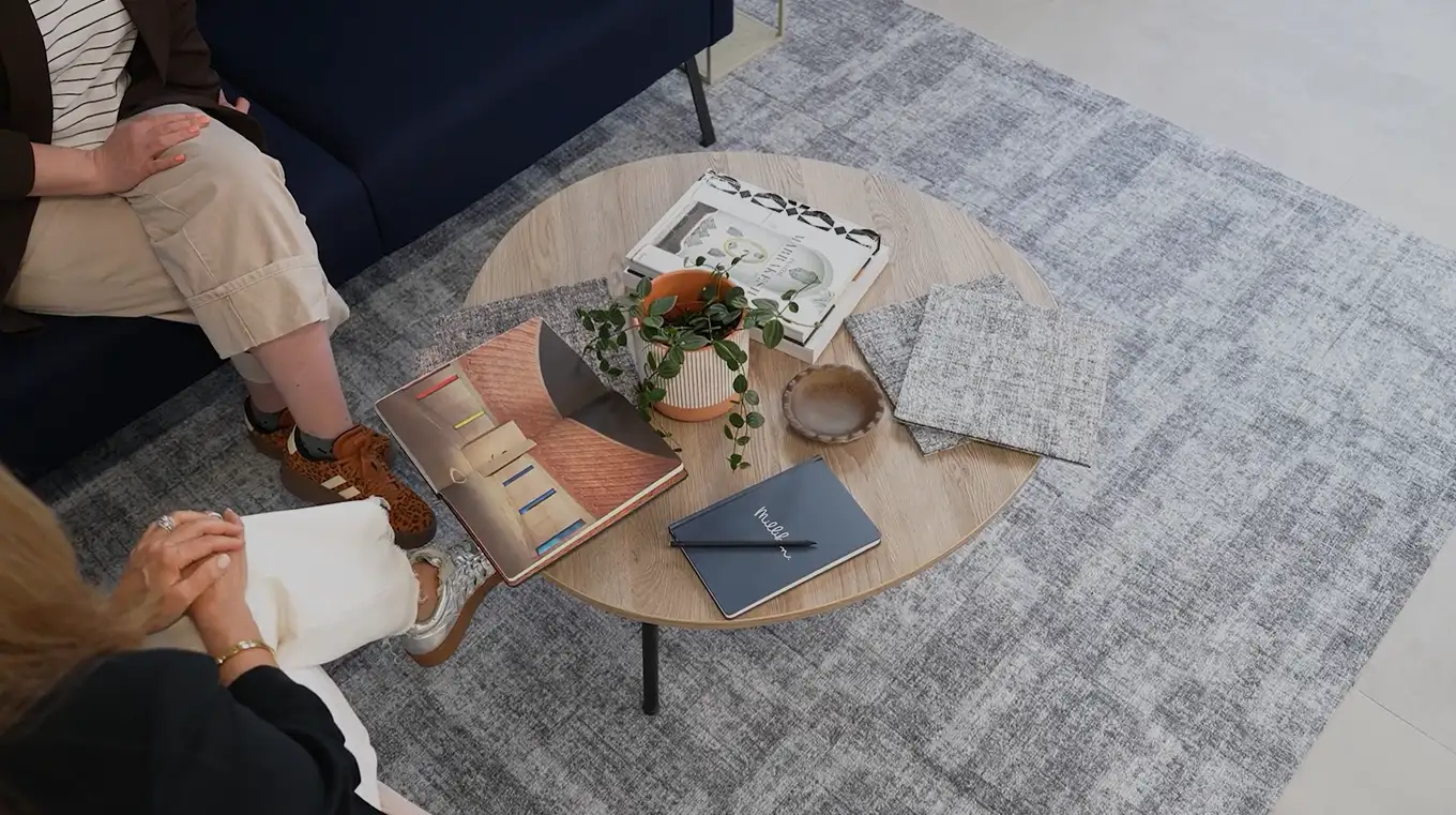 top view of people around a table with inspirational drawinging and notes on carpet tile for the the Quite Statement collection