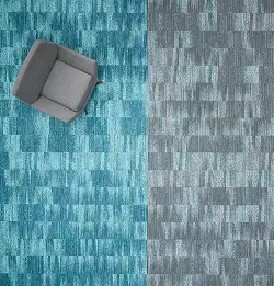 Aerial view of a chair on teal carpet tile transitioning to gray