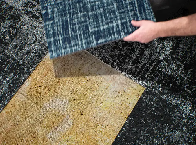 person placing Milliken carpet tile
