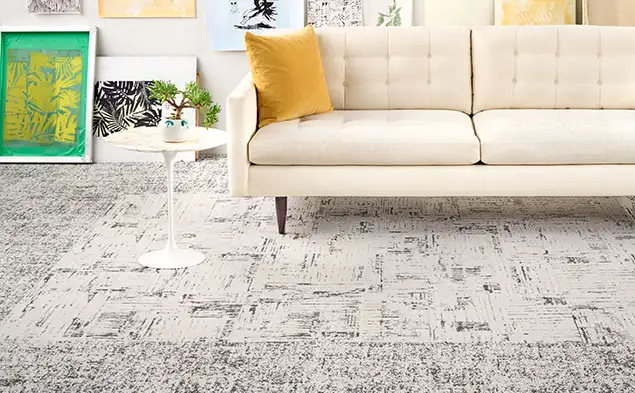 close up of sofa with yellow pillow on carpet tile from the Open Studio collection