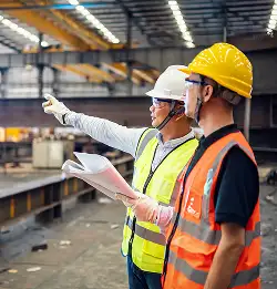 two people with hard hats talking