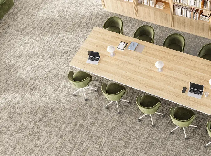 view from above with a large wooden table with green chairs on neutral flooring
