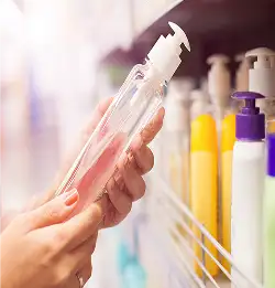 close shot of a person holding clear pump bottle in a store