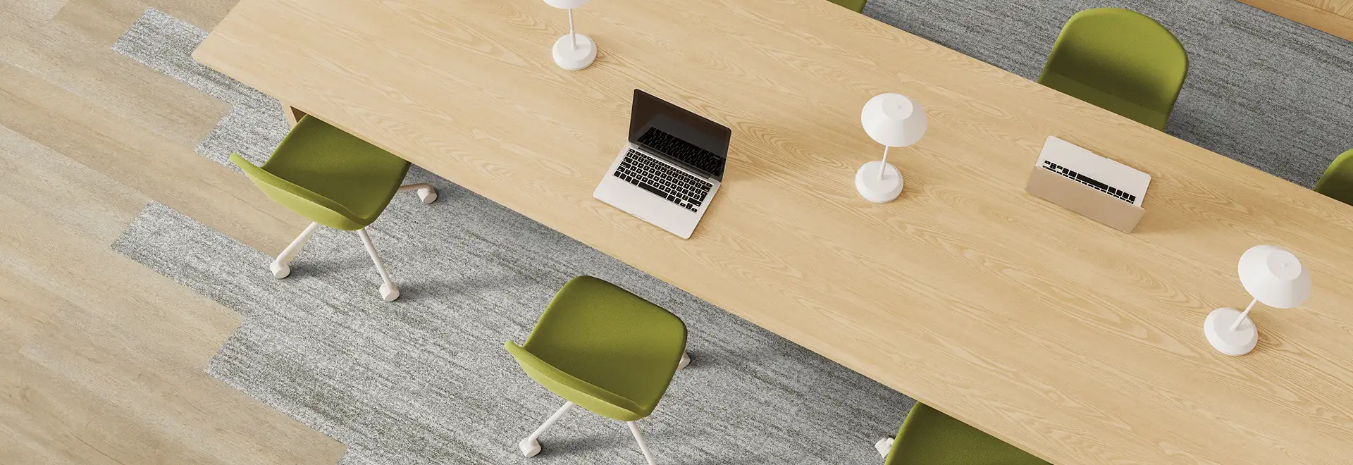 overhead view of large wooden table with green chairs on carpet and LVT plank flooring