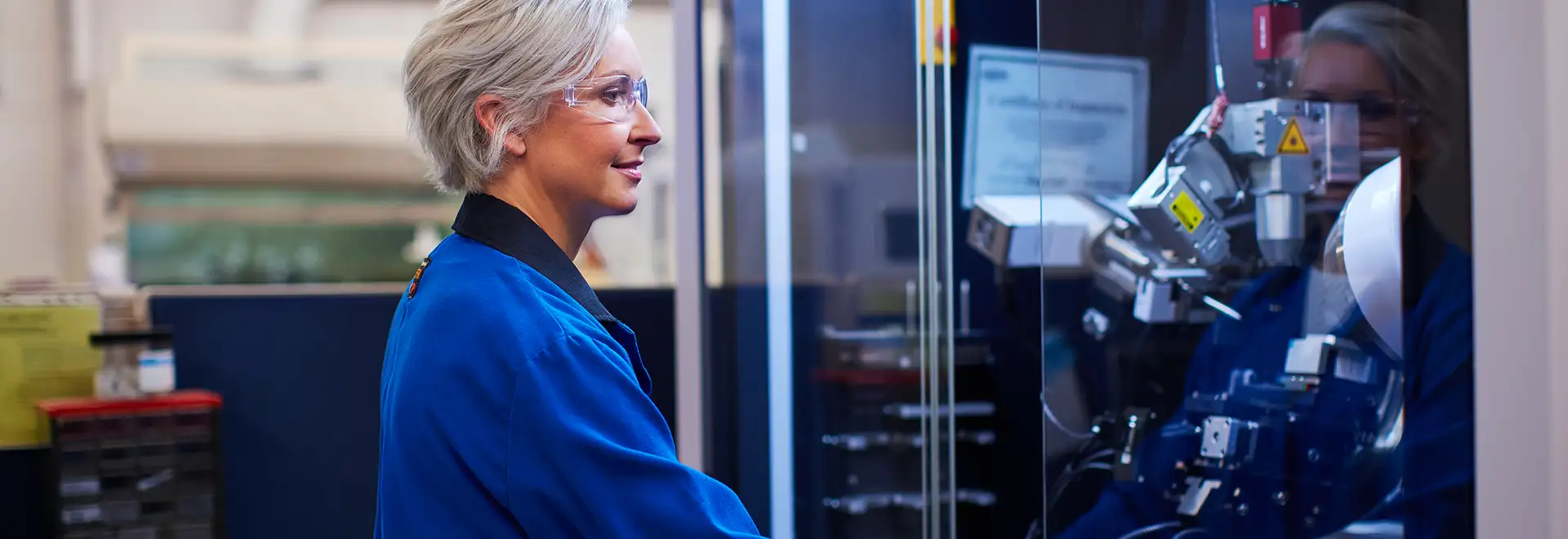 Lab tech wearing saftey glasses working on machine