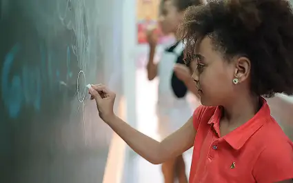 Child writing on chalk board