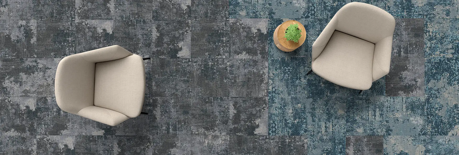 view from above of seating area with two padded chairs and a side tabel with plant on carpet tile from rtge Reevelation collection