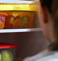 Tight shot of an opened refrigerator door with clear containers on the sleves