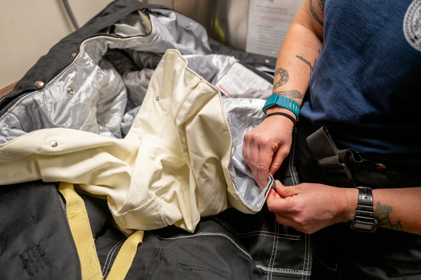 Firefighter showing the layers of fabric in firefighting suit
