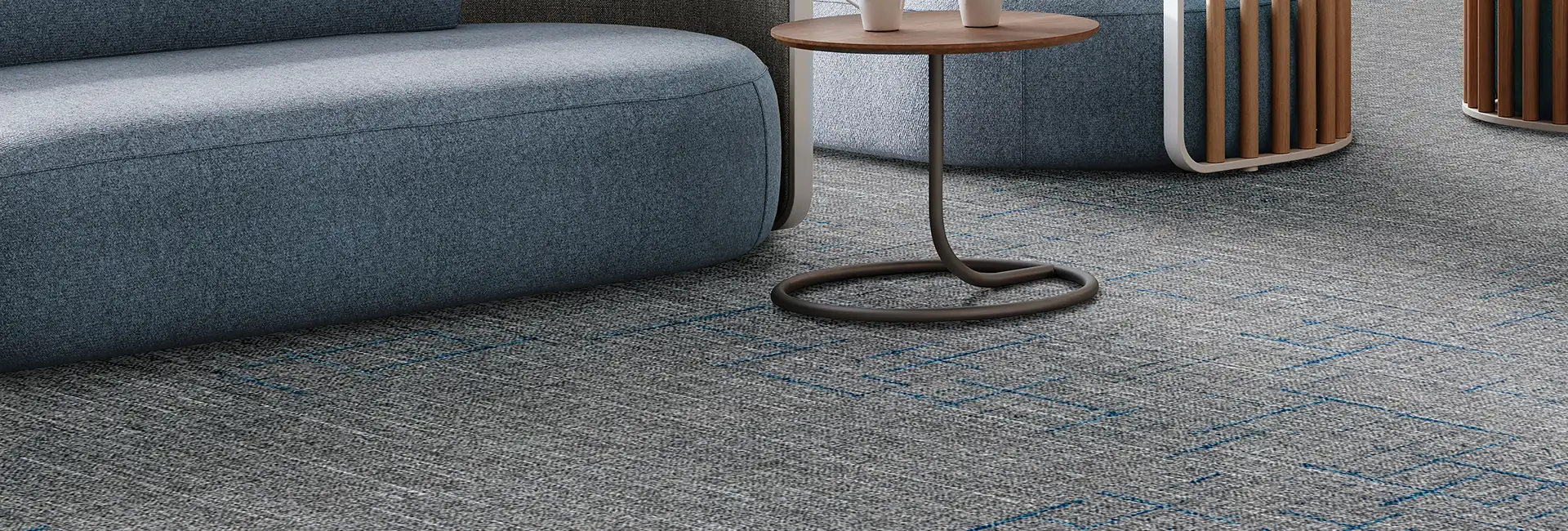 Close up of sofa on textured gray carpet tiles with teal accents