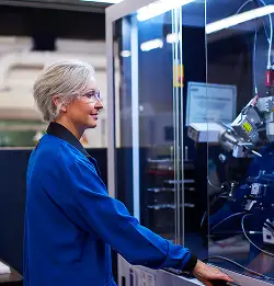 person with safety glasses working at a machine
