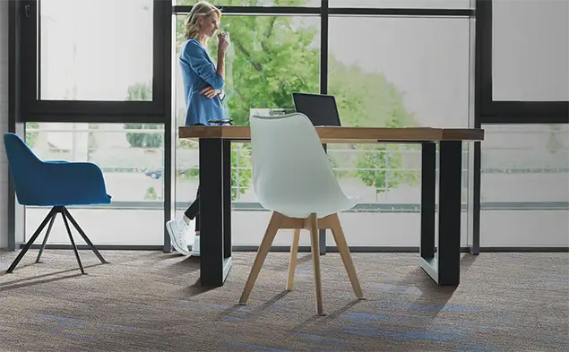 person drinking coffee in sitting area on Milliken carpet tile