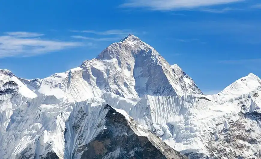 Majestic snow covered mountain against a blue sky