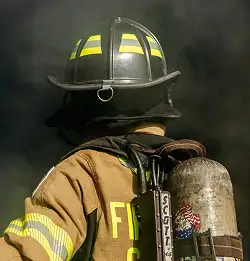 actibe Firefighting wearing Milliken turnout gear surrounded by smoke