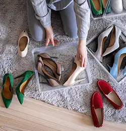 shopt from above of a person organizing shoes in clear containers
