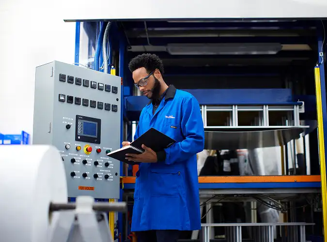 person in workwear operating technical machine