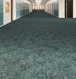 low shot of a schoold hallway with teal carpet tile that matches the locker color