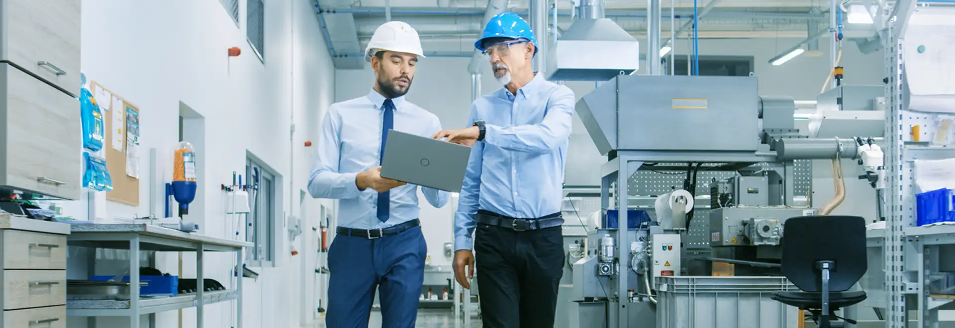 two people with hard hats on production floor