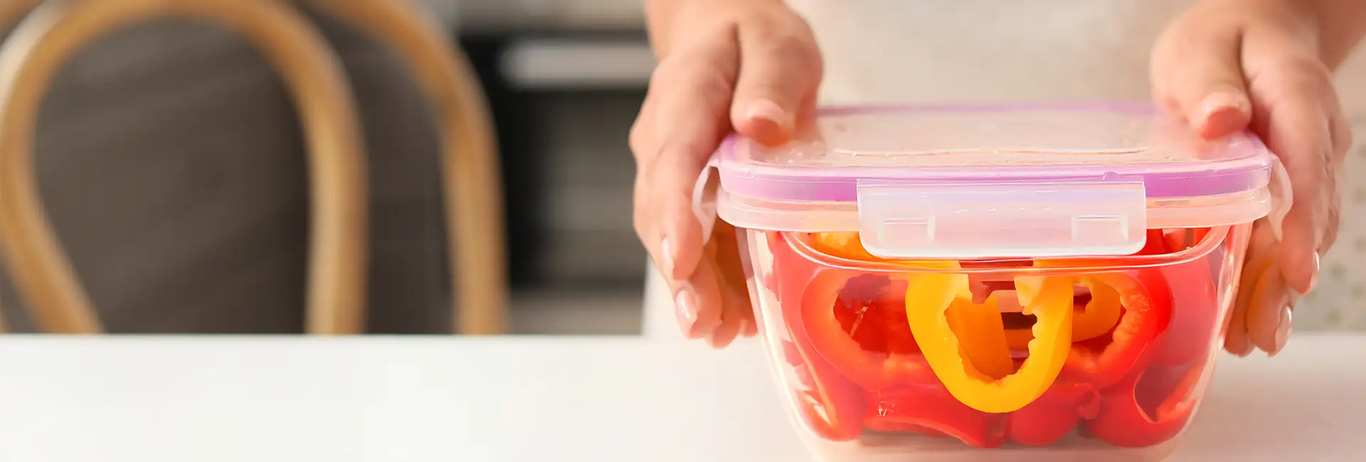 Clear food container with person sealing the lid