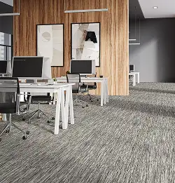 Modern office space with wood wall, white tables and gray carpet tile installation