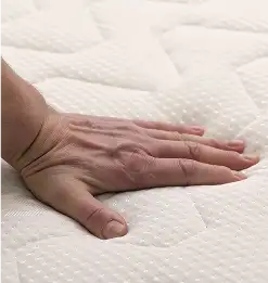 hand pushing down on matress