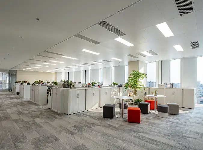 open office with white filing cabinets and gray plank carpet flooring