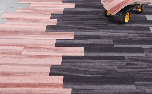 pink and gray plank carpet tile being installed