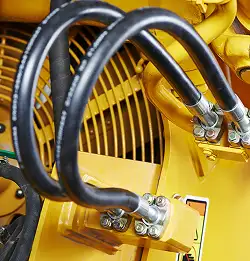 close shot of a yellow machine with black rubber hoses