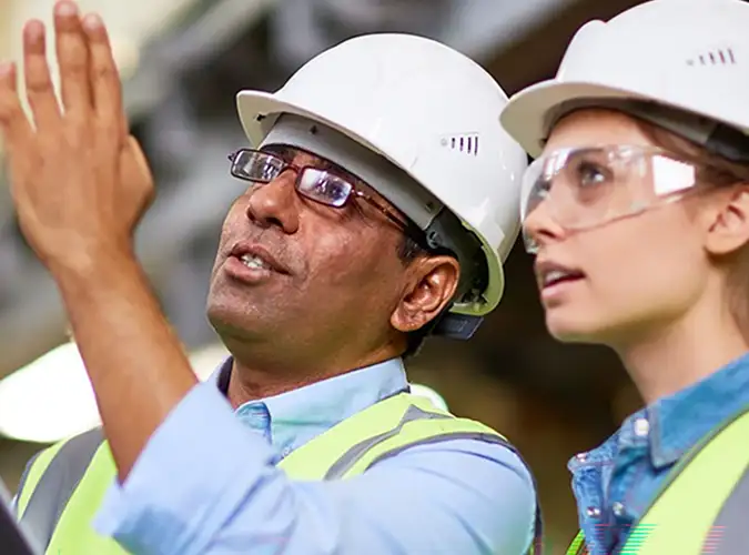 two people wearing safety gear talking