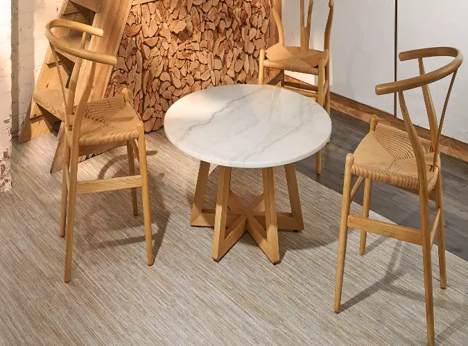 two blonde wood chairs with whiote marble topped table on QuietLife Resilient Flooring
