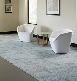 seating area with two white chairs, table and gray carpet tile installation