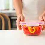 person sealing a clear food container