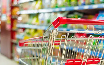 grocery cart with fullk shelves in the background