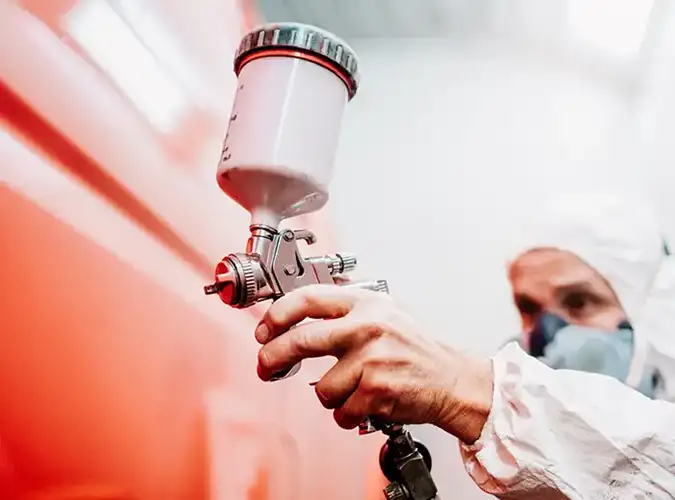 close up of person sraying a red car