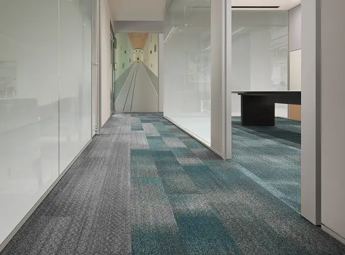 workplace hallyway with plank carpet tile flooring that transitions from gray to green