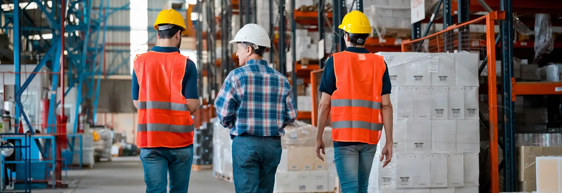 view from behind 3 associates walking on plant floor