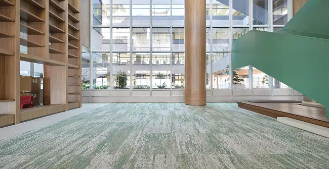 large public space with wood colums and walls with carpet tile floor