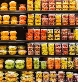 Grocery shelf filled with clear containers with fruits and vegetables