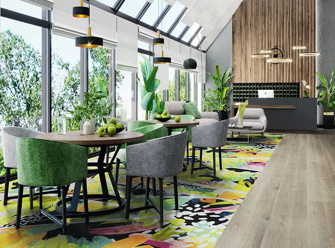 hotel public space with colorful carpet inset with LVT surrounding