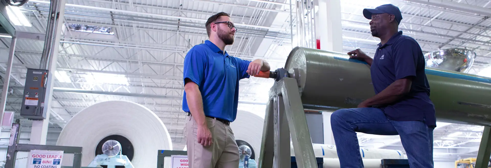 two associates talking on textile manufcaturing plant floor