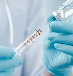 tight shot of a person filling a shot with blue green ruber gloves on hands