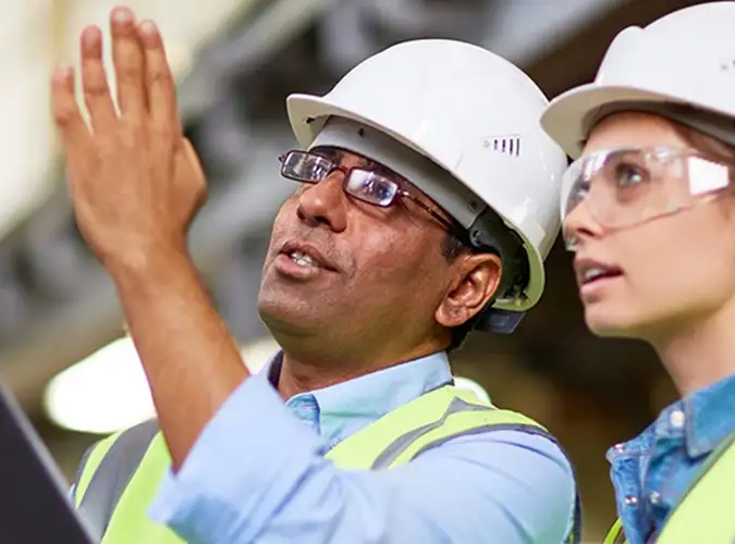 two people in hard hats sharing ideas