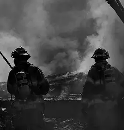 Firefighters approaching smoke filled area
