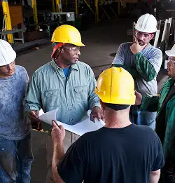 grouple of people with hard hats on plant floor