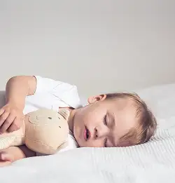 child sleeping with stuffed animal