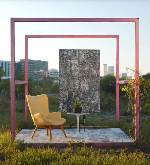 outside image with a yellow chair on a platform with Milliken carpet as a backdrop panel in a field