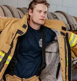 fire fighter putting on Milliken Flame-Resistant Materials